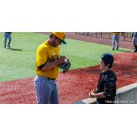 Normal CornBelters sign autographs for a young fan