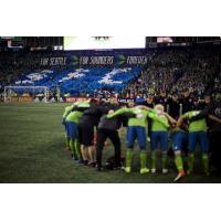 Seattle Sounders FC huddle in front of the Seattle crowd