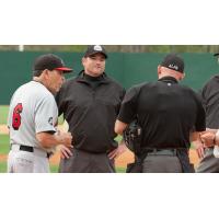 Road Warriors manager Ellie Rodriguez talks with the umpires